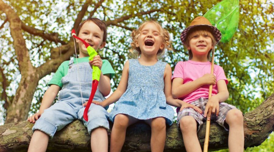 Kinder sitzen auf dickem Ast
