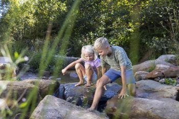 Kinder spielen am Bach