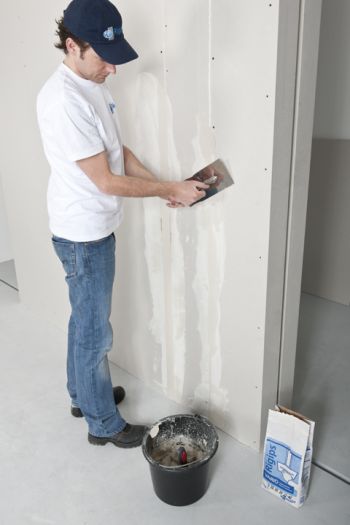 Mann verspachtelt Gipskartonplatten