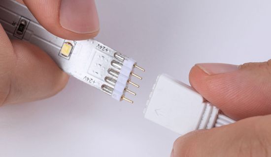 Hände stecken zwei Enden von LED-Streifen ineinander