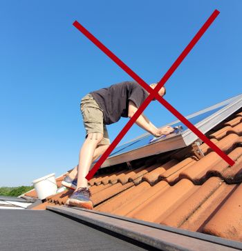 Mann putzt Solaranlage