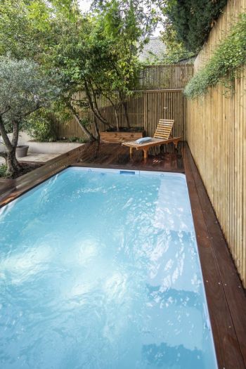 Kleiner, rechteckiger Pool mit Sichtschutzwänden aus Bambus