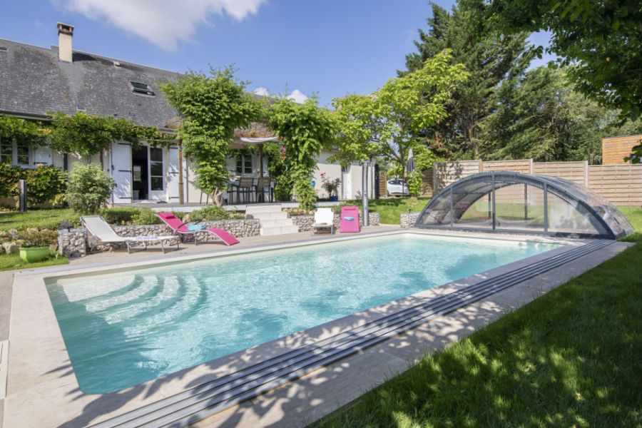 Aufgeklappter überdachter Pool neben Haus