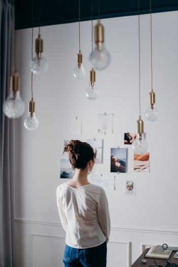 Frau betrachtet Bilder an der Wand