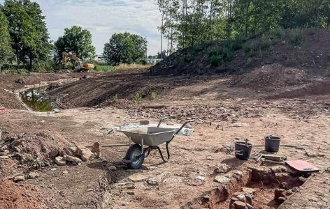 Ausgrabungsgelände mit freigelegten Steingräber und Schubkarre