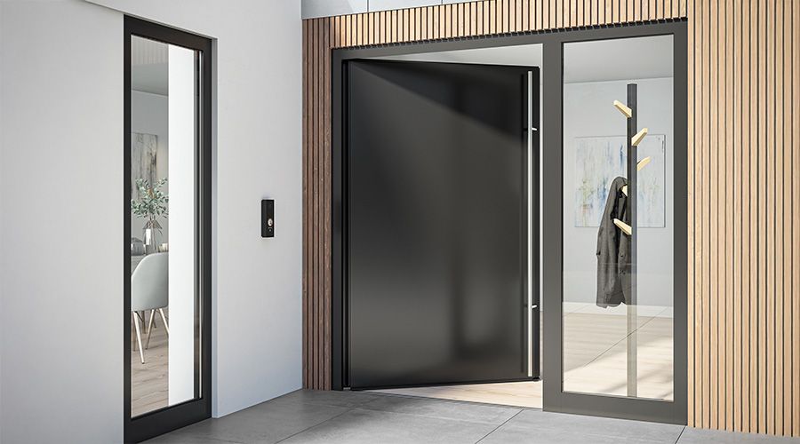 Das Bild zeigt einen modernen Eingangsbereich mit einer großen, schwarzen Tür, die weit geöffnet ist. Die Türschwelle ist flach. Links befindet sich ein schmaler Fensterbereich, während rechts eine Garderobe mit einem hängenden Mantel sichtbar ist.