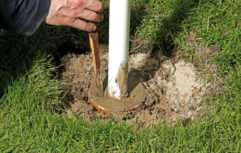 Beton wird mit Holzstück verdichtet