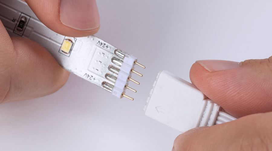 Hände stecken zwei Enden von LED-Streifen ineinander